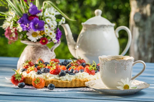 Fruit tart served with coffee in the summer garden — Stock Photo, Image