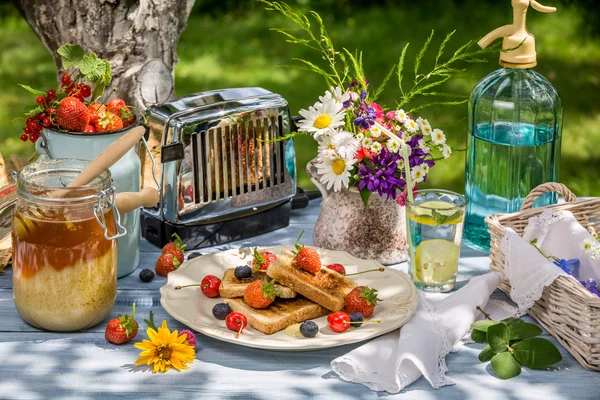Sommarfrukost i trädgården med frukt toast med honung — Stockfoto