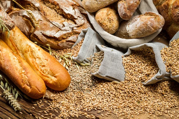 Vários tipos de pão de trigo integral na velha mesa de madeira — Fotografia de Stock