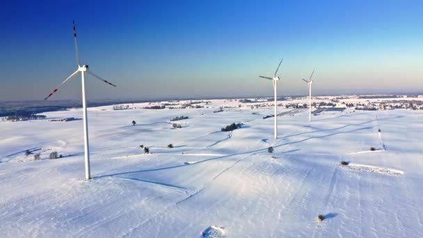 阳光明媚的冬日，雪地上的冬季风力涡轮机. — 图库视频影像