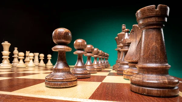 Closeup of chess shown in an unusual way on green background.