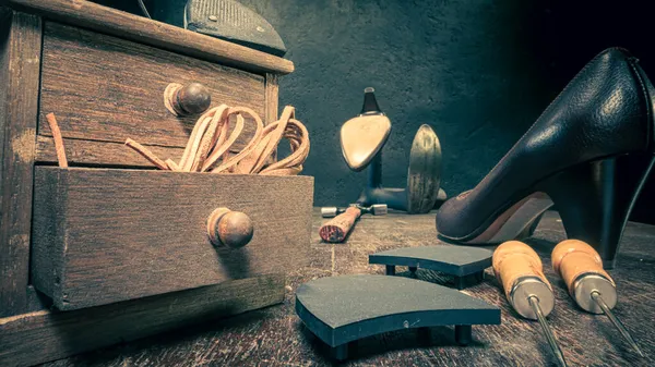 Traditional shoemaker workshop with tools, strap, leather and rules. Traditional shoemaker workshop