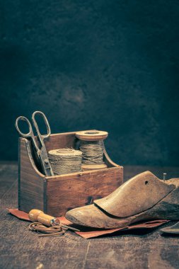 Antique cobbler workplace with tools, strap, leather and rules. Antique cobbler workplace clipart