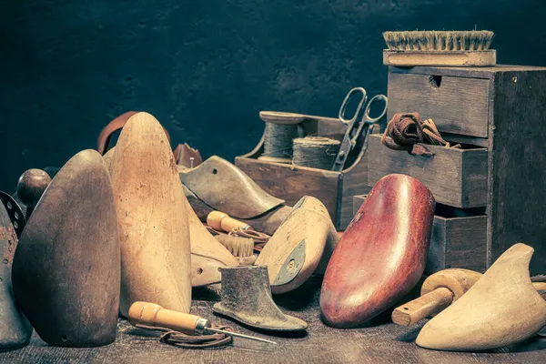 Vintage shoemaker workshop with tools, laces and shoes. Vintage shoemaker workshop