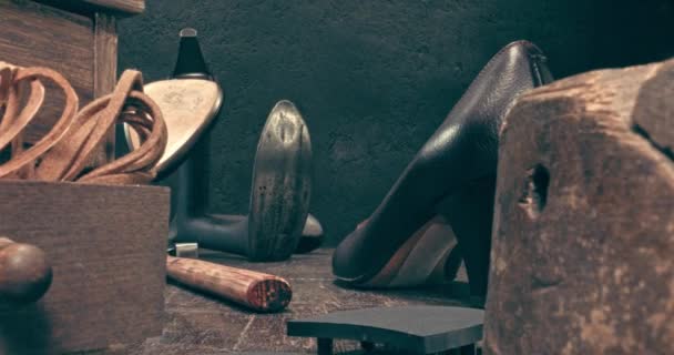Oficina de sapateiro com ferramentas, bigorna, sapatos e regra. — Vídeo de Stock