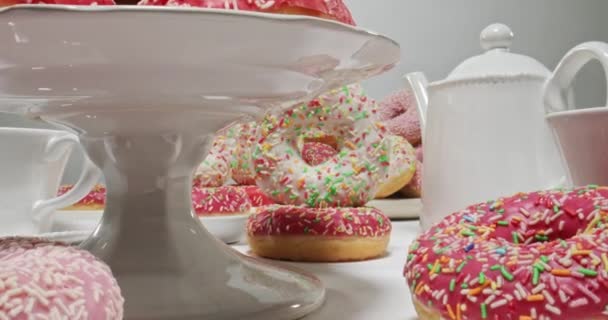 Tisch mit Donuts und Kaffee. Donuts mit Zuckerguss und Streusel. — Stockvideo
