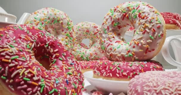 Bunte Donuts mit Streuseln. Weiße und rosa Donuts mit Glasur. — Stockvideo
