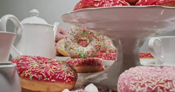 Donuts multicoloridos com polvilhas. Mesa com donuts e café. — Vídeo de Stock