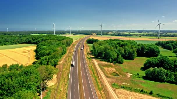 Luchtfoto van gouden veld en windturbines in de buurt van de snelweg. — Stockvideo