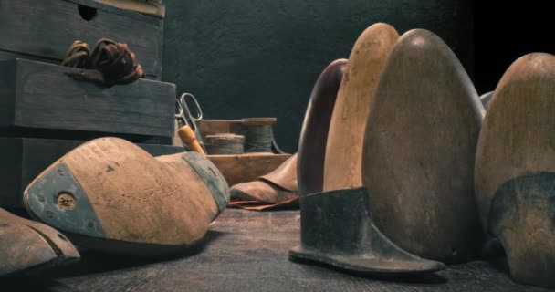 Старое рабочее место сапожника с инструментами, шнурками и обувью. — стоковое видео