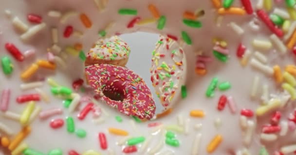 Colorful donuts with sprinkles. White and pink donuts with glaze. — Stock Video