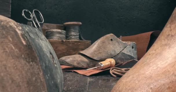 Χώρο εργασίας του τσαγκάρη με εργαλεία, παπούτσια και τα κορδόνια. — Αρχείο Βίντεο