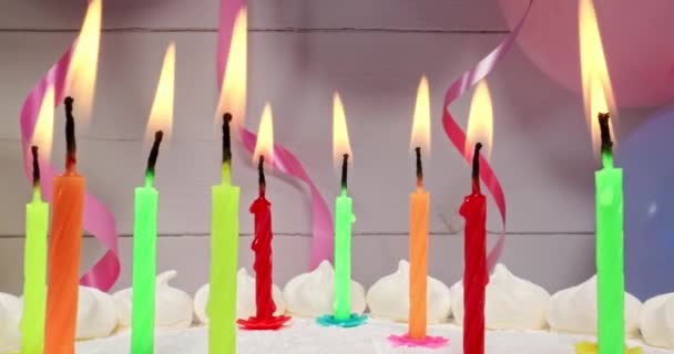 Brandende kaarsen op cake op ballonnen en linten achtergrond. — Stockvideo