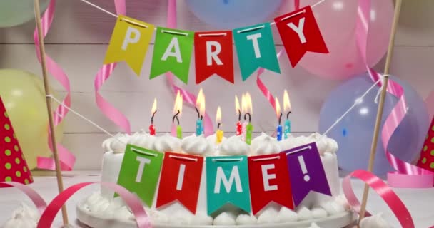 Verjaardagstaart met brandende kaarsen met ballonnen op achtergrond. — Stockvideo