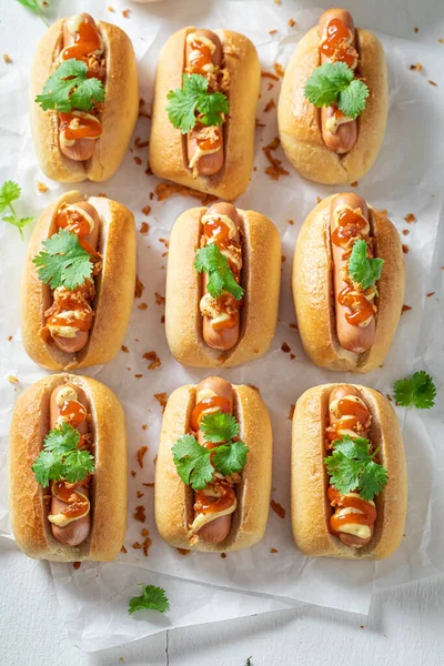 Hot and homemade mini hot dogs as fast food. Mini hot dogs with spicy sausage and mustard.