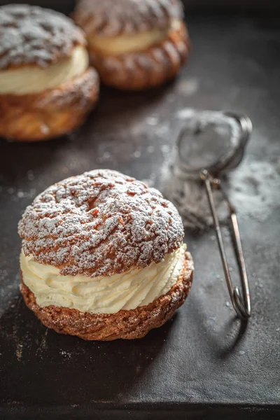 Delicious and fresh cream puffs made of vanilla cream and sugar. Cream puffs as a small sweet snack.