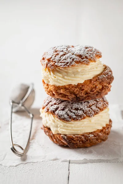 Tasty and homemade cream puffs with sugar and vanilla cream. Cream puffs as a small sweet snack.