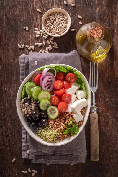 Colorful Greek salad in the fit version with buckwheat groats. Nutritious bowl for fit people.