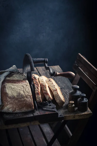 Healthy and tasty loaf of bread with on old slicer. A loaf of bread on a crumb slicer.