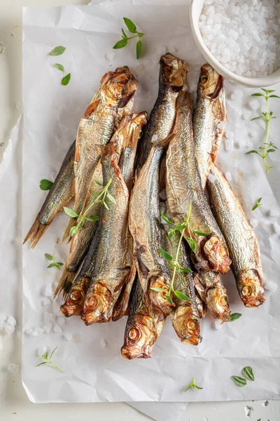 Tasty smoked sprats as appetizer by the sea. Smoked fish marinated with salt and herbs.