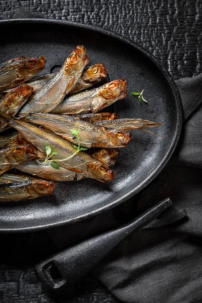Tasty smoked sprats with herbs and salt. Smoked fish marinated with salt and herbs.