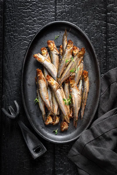 Healthy smoked sprats as appetizer by the sea. Smoked fish marinated with salt and herbs.