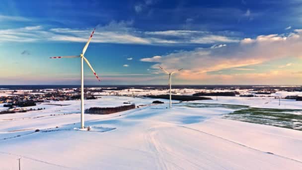 冬の日の出に美しい雪原と風力タービン 空中風景 — ストック動画