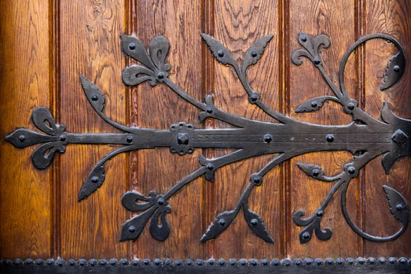 Ornamento de metal en la puerta de madera — Foto de Stock