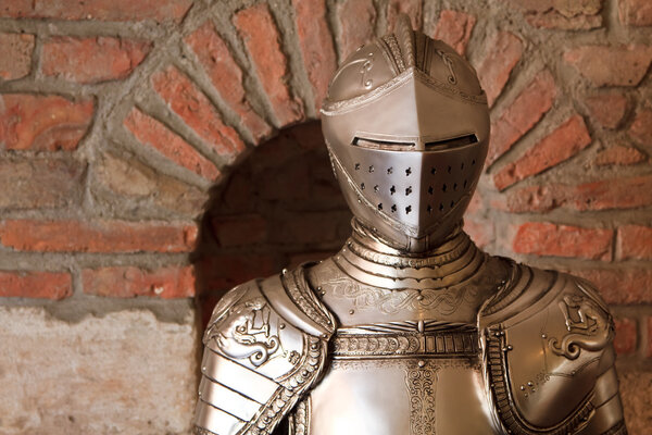 A knight's armour with shining metal and ornate shield and sword