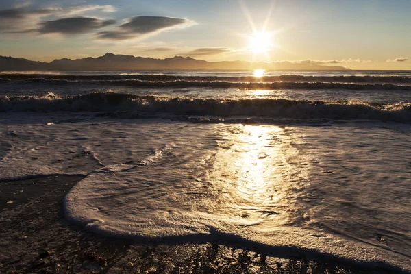 günbatımı yakınındaki köpüklü dalgalar