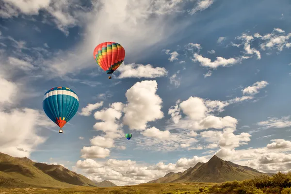 Hot air balloons over mountains — Stock Photo, Image