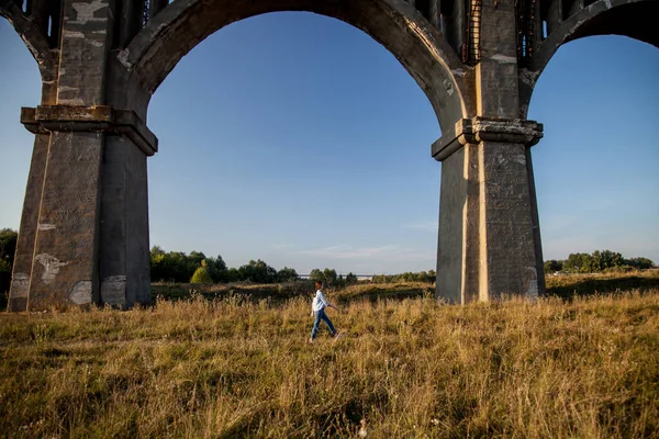 a huge old aqueduct and a little man under it