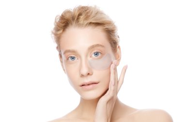 Kollajen göz bandı tutan güzel bir kadın, beyaz arka planda izole edilmiş.