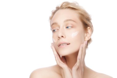 Yüz kremi süren güzel bir genç kadının yakın plan güzel portresi.