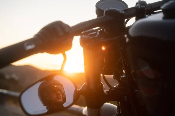 Motociclista mirando a través del espejo de su bicicleta Imagen de archivo