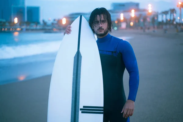 Surfer στέκεται και κρατώντας σανίδα του surf, έτοιμος για σέρφινγκ στην παραλία της Βαρκελώνης Royalty Free Εικόνες Αρχείου