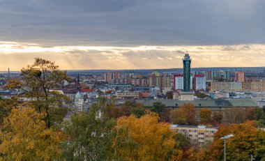 Ostrava Yeni Belediye Binası 'nın, yakınlardaki binaların ve sonbaharda yeşilliklerin bir resmi..