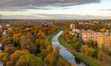 Ostravice nehrinin bir resmi ve sonbaharda gün batımında yapraklar..