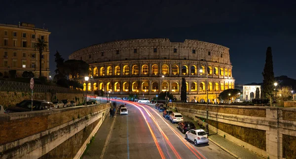 Yakındaki bir yaya köprüsünde geceleri Colosseum 'un bir resmi görülüyor..