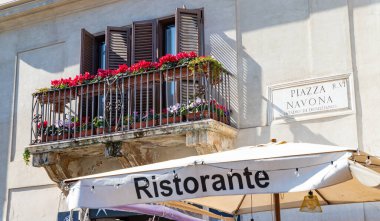 Restoran tentesinin resmi, güzel bir balkon ve Piazza Navona plaketi..