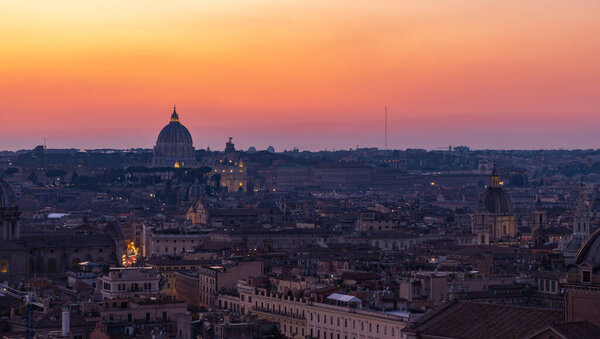 A picture of the St. Peter's Basilica overlooking the city of Rome at sunset.