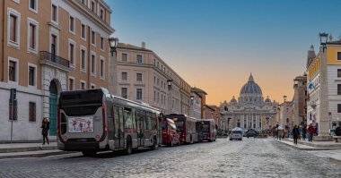 Aziz Peter Bazilikası ve Via della Conciliazione 'nin gün batımında trafikte birkaç otobüsle çekilmiş bir fotoğrafı..