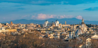 Gün batımında Roma 'nın simgelerinin ve çatılarının bir resmi..