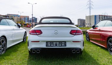Bir araba galerisindeki beyaz Mercedes Benz sınıfı C Cabrio 'nun dikiz görüntüsü..