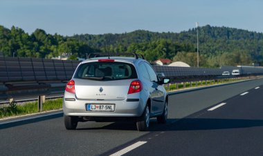 Slovenya otoyolunda gümüş renkli bir Renault Clio resmi.