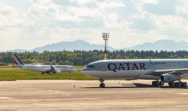 Bir Air France uçağı ve Ljubljana Havaalanı 'na park etmiş bir Katar Havayolları uçağı fotoğrafı..