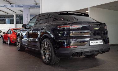 A picture of a black Porsche Cayenne inside a dealership.