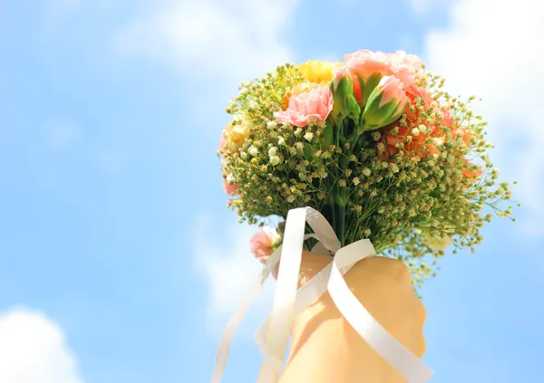 Kytice květin v rukou a modré nebe — Stock fotografie