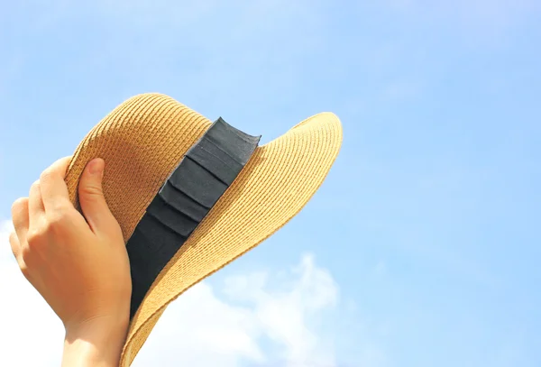 Woman hand holding panama hat with blue sky — Stock Photo, Image