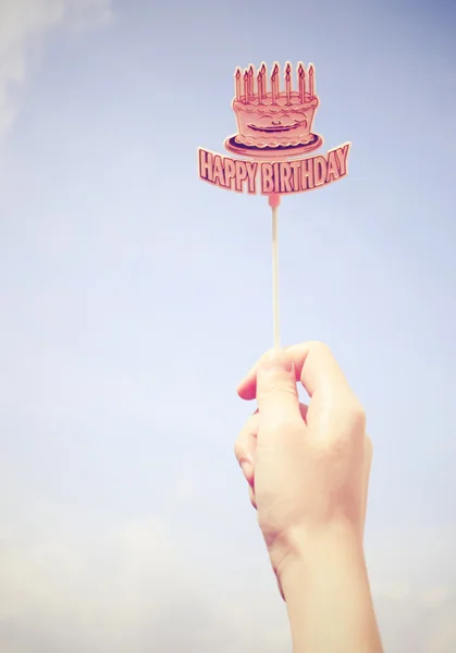 Hand holding happy birthday tag with blue sky, retro filter effe — Stock Photo, Image